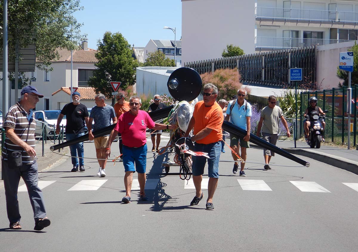 Bénévoltes et équipe poussent le mât