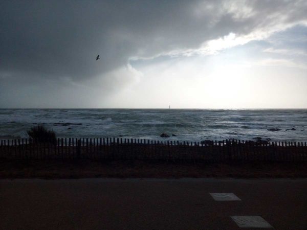 Stürmischer Tag, aufgewühltes Meer, Leuchtturm, Wolken, Seevogel vor Les Sables d'Olonne