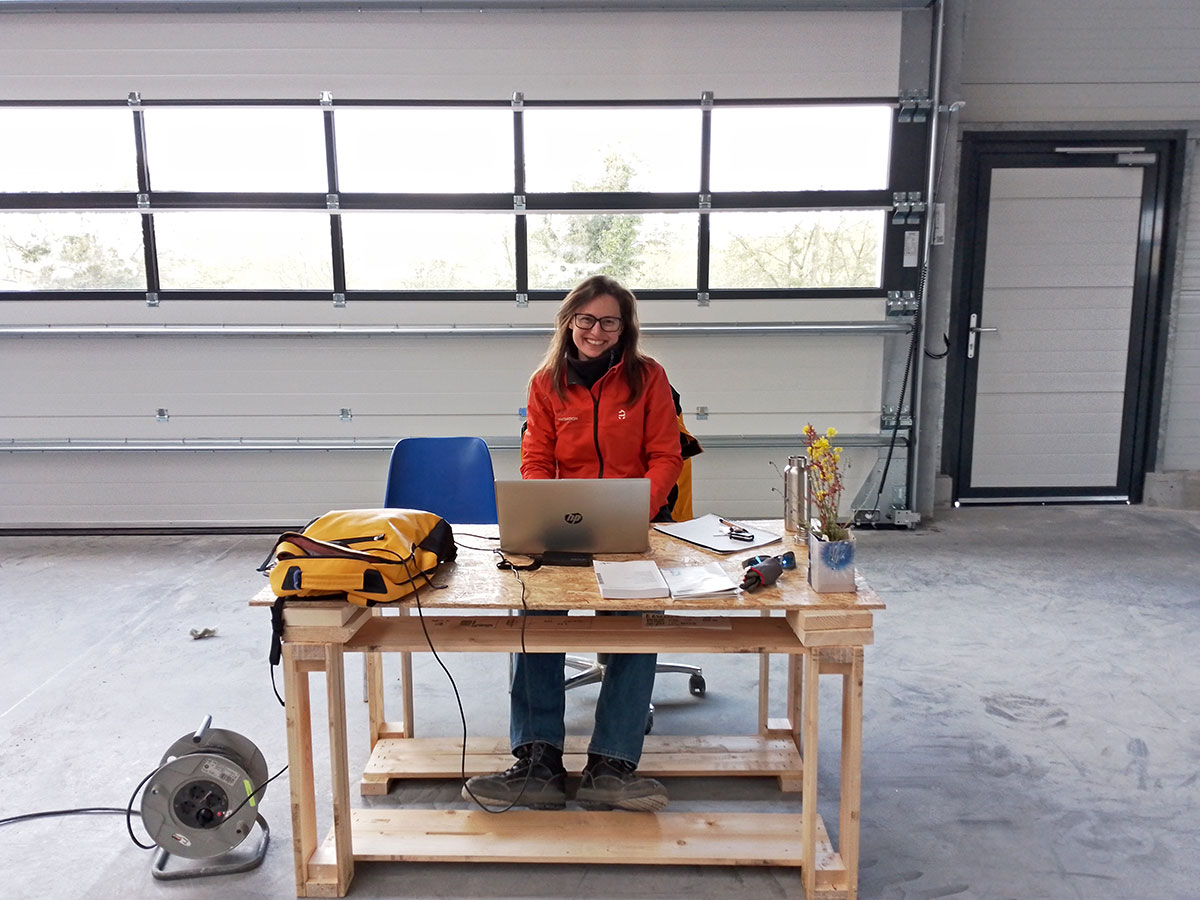 Marion sitting next to her improvised office table in the big shipyard