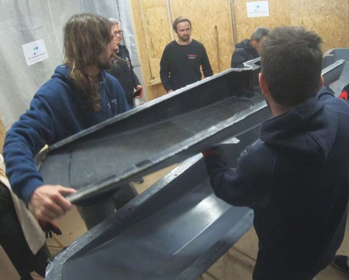 Die Teammitglieder des Workshops entformen das am Vortag laminierte Teil.