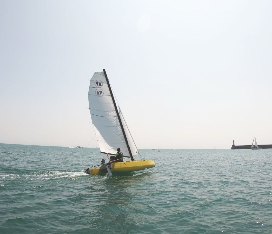 Yellow Volcat16 heeling in front of Les Sables d'Olonne pier