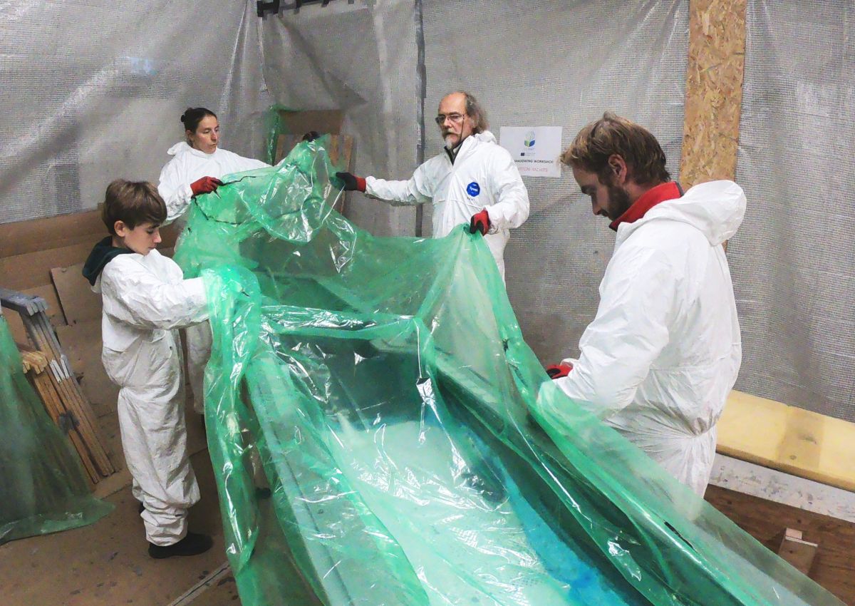 L'équipe IY retire le sac sous vide après avoir stratifié la moitié de la coque du VOLCAT16.