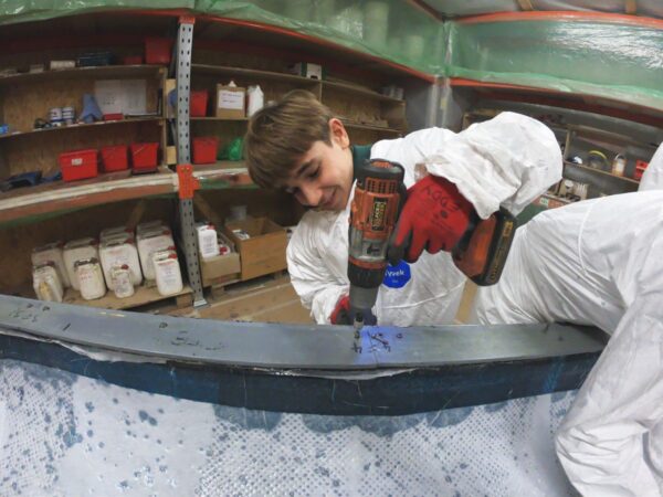 Téo retrieving a screw of the frame for the hull of Volcat16 with a screwdriver