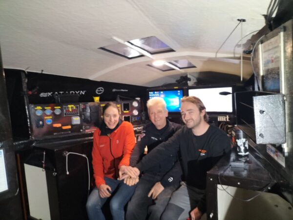 Inside of the cockpit, from left to right: Annie, Norbert and Benoit joining their hands as a team