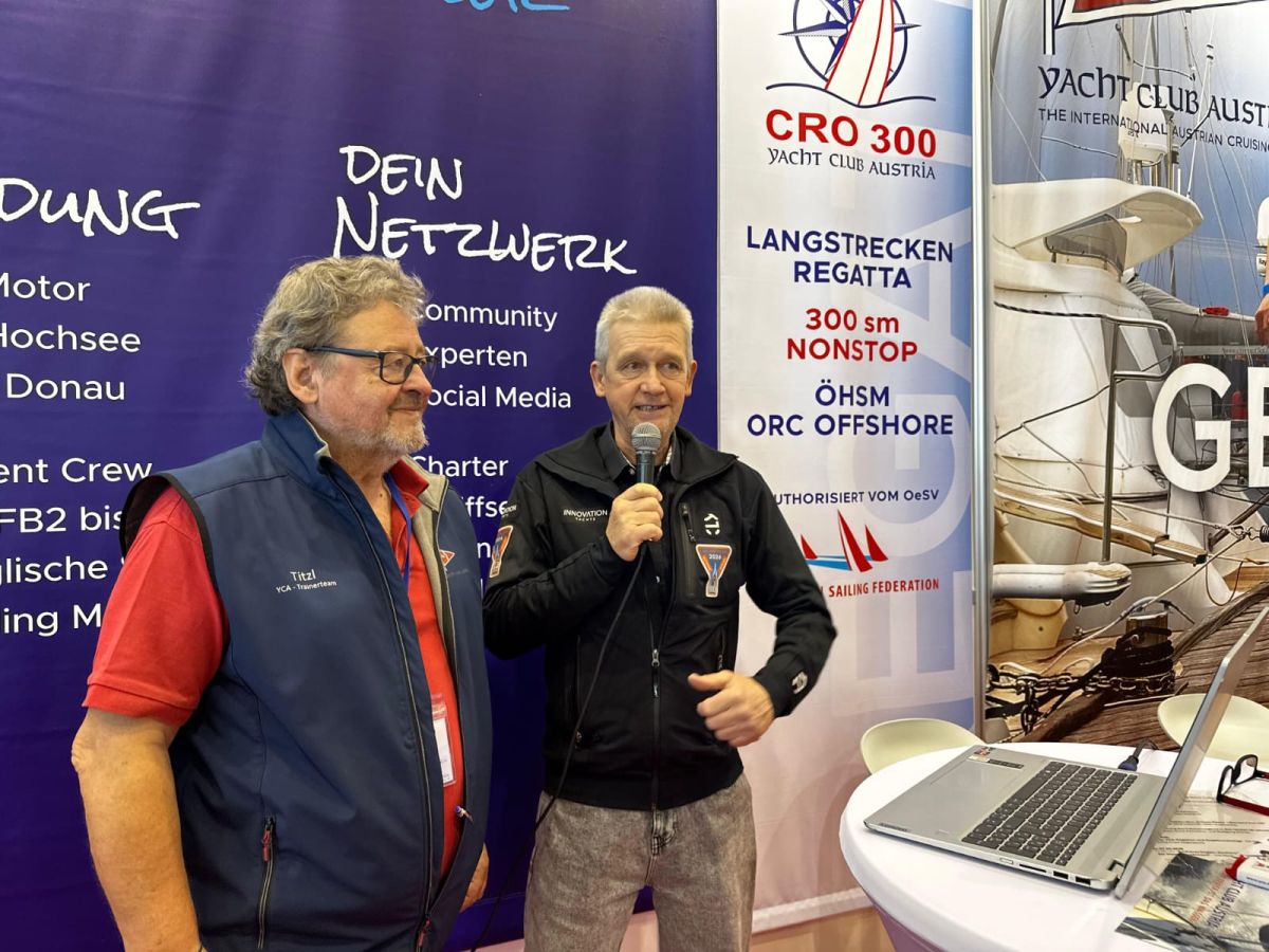 Norbert steht neben Gottfried Rieser am Stand der YCA und spricht ins Mikrofon.