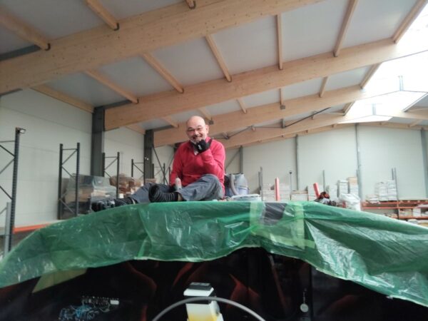 Edouard, crew member, is sitting on the deckhouse, thumb up, in socks and smiling !