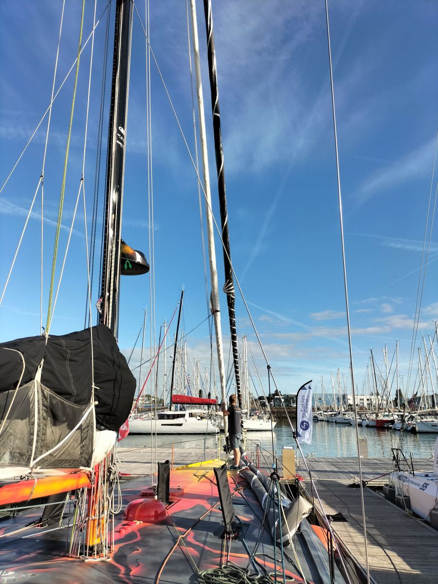 Team member rolling up a foresail on the Open60AAL - ANT ARCTIC LAB