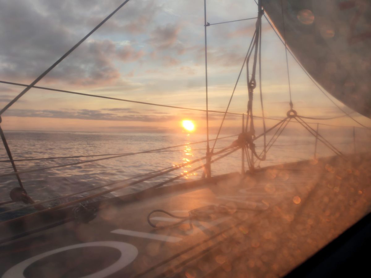Ein orangefarbener Sonnenuntergang, gesehen durch ein Backbordfenster der Open60AAL. – ANT ARCTIC LAB